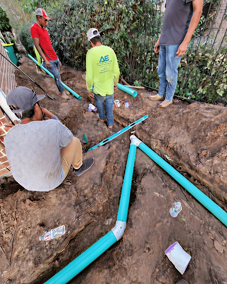 Crew laying blue drainage pipe in a residential yard in Montgomery County