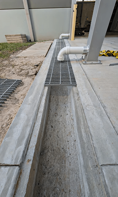 Concrete channel drain with steel grate installed in a driveway
