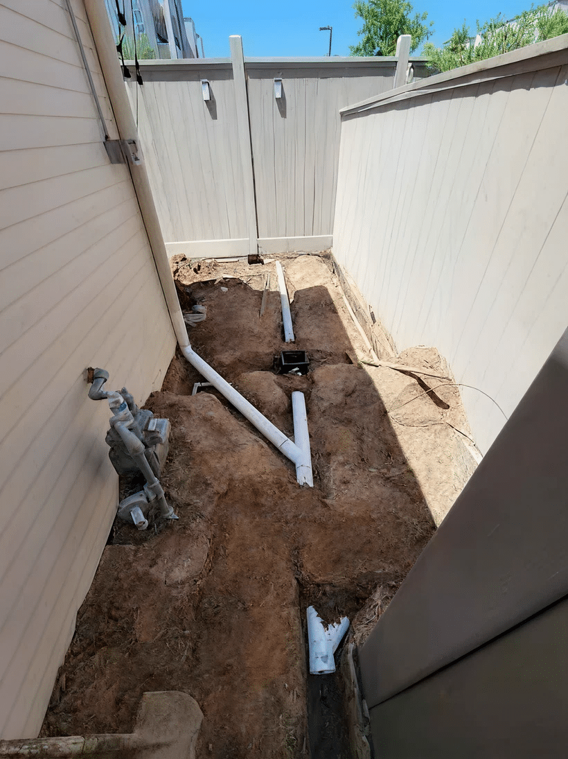 French drain trench with perforated pipe and gravel installed in a Montgomery County yard